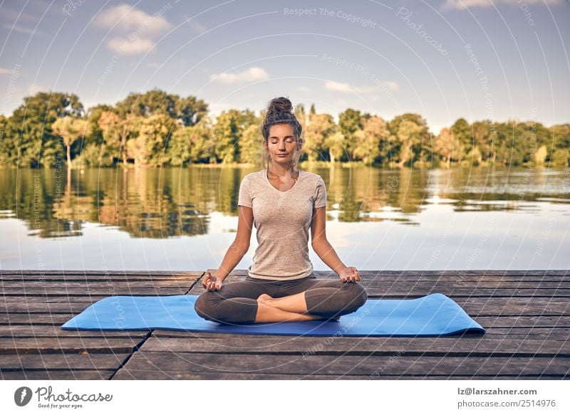 Lächelnde Frau, die auf einem Holzdeck meditiert. Lifestyle Glück Körper Wellness Meditation Sommer Meer Yoga Erwachsene 1 Mensch 18-30 Jahre Jugendliche Natur