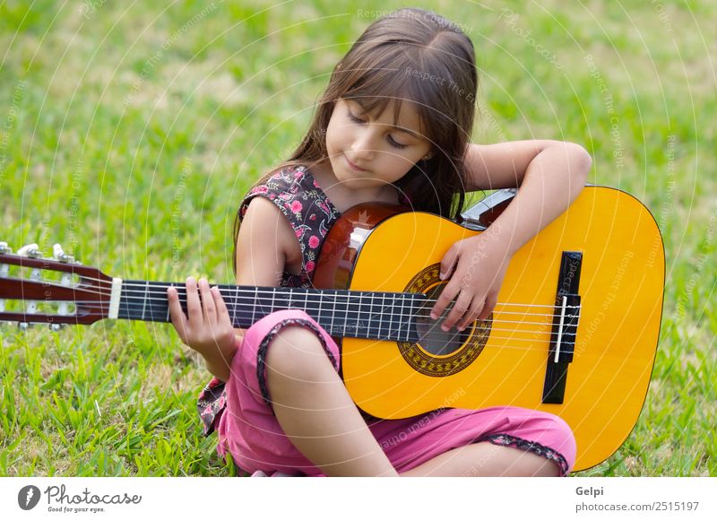 Mädchen mit Gitarre Freude Glück schön Spielen Musik Kind Mensch Kindheit Hand Finger Musiknoten Gras sitzen Fröhlichkeit klein niedlich grün rosa unschuldig