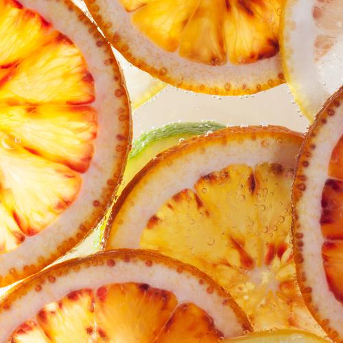 Makroaufnahme - Eine grüne Limette unter Orangen Frucht Zitrone Bioprodukte Lebensmittel Vegetarische Ernährung Erfrischungsgetränk Trinkwasser rund saftig