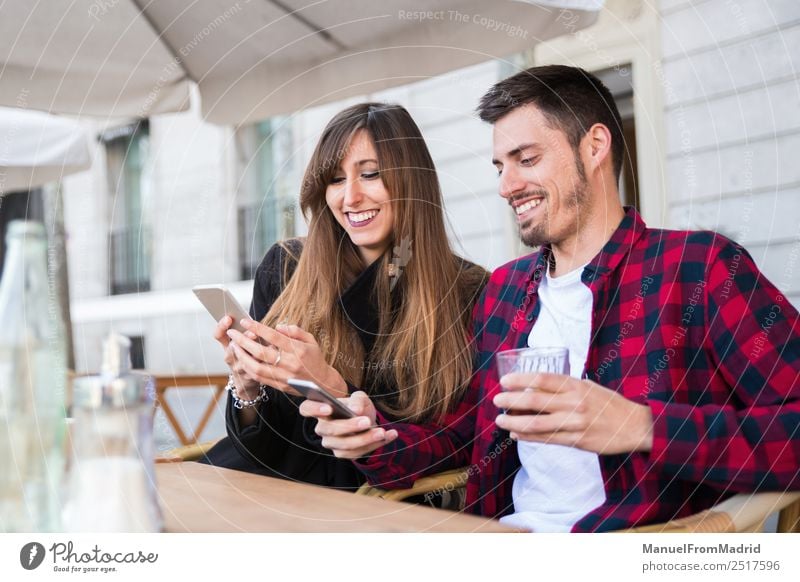 junges Paar auf der Terrasse sitzend Lifestyle Glück Freizeit & Hobby Ferien & Urlaub & Reisen Tisch Restaurant Telefon PDA Technik & Technologie Internet Frau