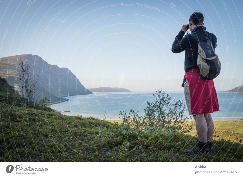 Junger Mann schaut durch ein Ferglas auf einen Fjord Erholung Ferien & Urlaub & Reisen Ausflug Abenteuer Ferne Freiheit wandern Jugendliche Landschaft Norwegen