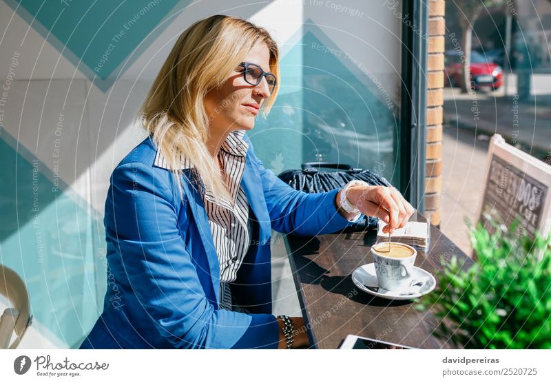 Junge Frau beim Mischen von Kaffee Lifestyle kaufen schön Freizeit & Hobby Tisch Arbeit & Erwerbstätigkeit Telefon PDA Mensch Erwachsene blond Denken