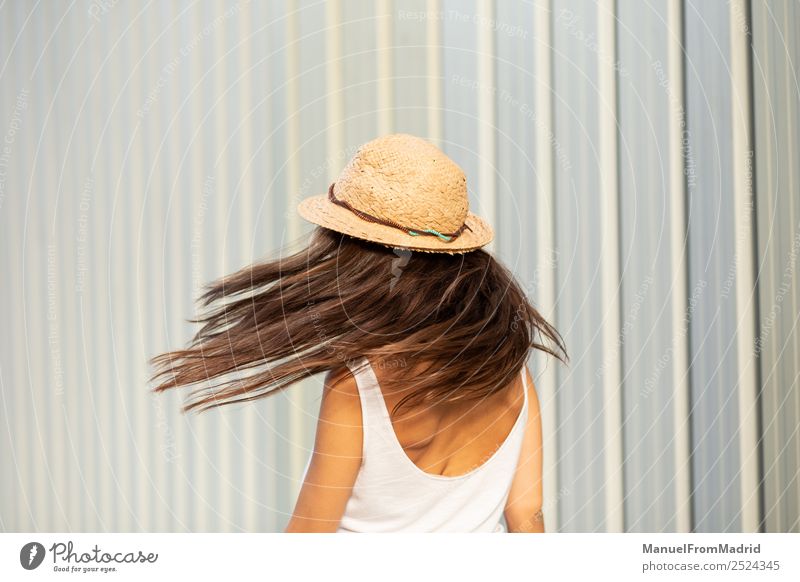 Rückansicht einer Frau mit einem Hut, der den Kopf schüttelt. Lifestyle elegant Freude Glück schön Sommer Mensch Erwachsene Mode Kleid brünett Bewegung stehen