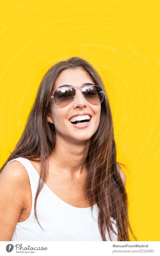 attraktive junge Frau mit Sonnenbrille auf gelbem Hintergrund Stil Freude Glück schön Sommer Mensch Erwachsene Mode Lächeln stehen trendy modern niedlich heiter