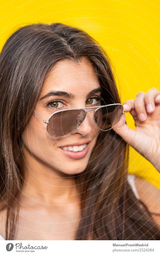 attraktive junge Frau mit Sonnenbrille auf gelbem Hintergrund Stil Freude Glück schön Sommer Mensch Erwachsene Mode Lächeln stehen trendy modern niedlich heiter