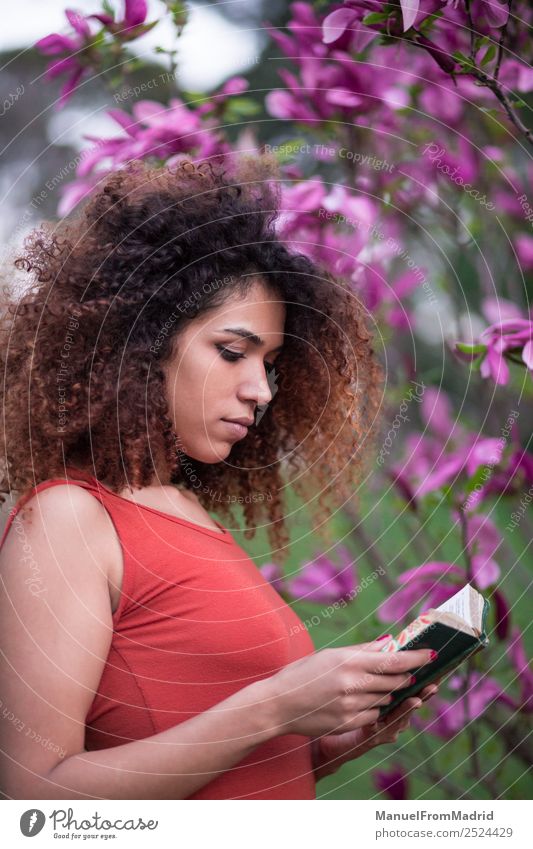 Afrofrau beim Lesen eines Buches im Freien Lifestyle Glück schön Freizeit & Hobby lesen Sommer Garten Schule lernen Mensch Frau Erwachsene Natur Baum Blume Gras