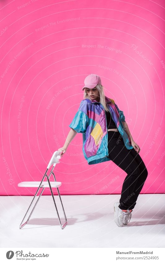 Stilvolle junge Frau posierend Lifestyle schön Schminke Stuhl Erwachsene Mode Bekleidung retro verrückt Coolness 80s rosa Hintergrund Beute anlehnen Teenager
