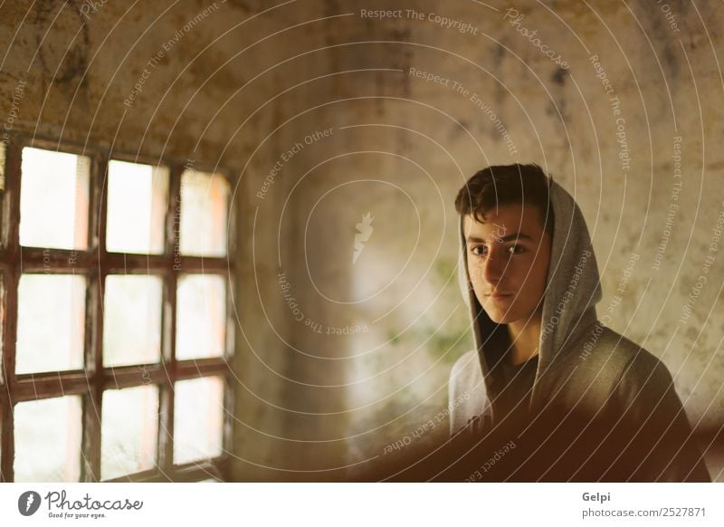 Jugendlicher mit Kapuze in einem verlassenen Haus, beleuchtet von einem Windlicht Lifestyle Gesicht Kind Mensch Junge Mann Erwachsene Straße Mode Traurigkeit