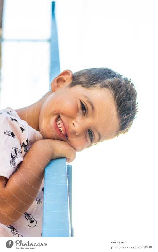 Kleiner Junge, der sich auf ein Geländer in einem weiß-blauen Dorf stützt. Lifestyle Freude Glück schön Gesicht Ferien & Urlaub & Reisen Sommer Kind Schule