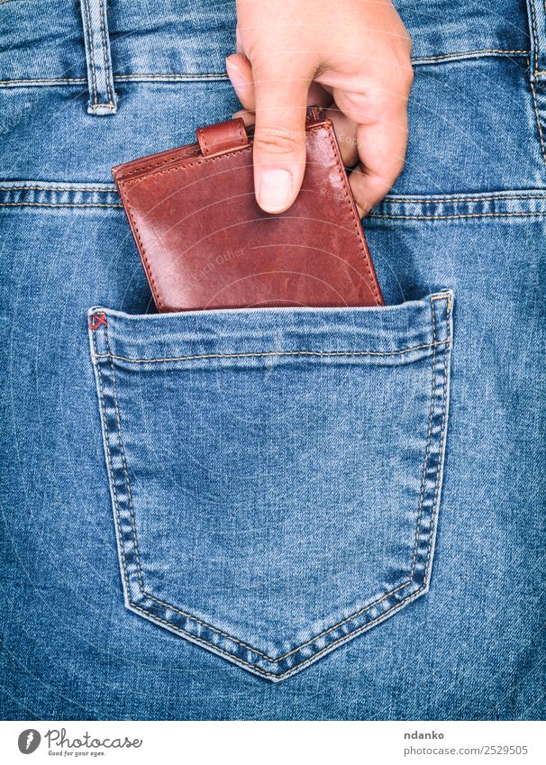 weibliche Hand klammert sich an eine Handtasche. Stil Geld Business Mensch Frau Erwachsene Mode Bekleidung Hose Jeanshose Stoff Leder festhalten blau braun