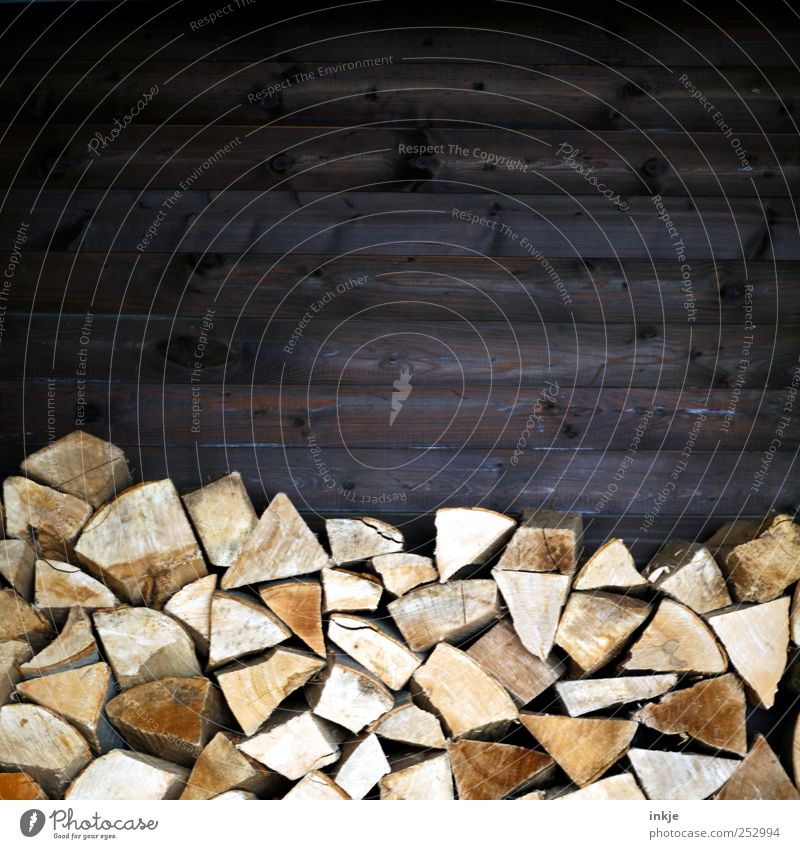 Brennholz Häusliches Leben Energiewirtschaft Erneuerbare Energie Energiekrise Herbst Winter Mauer Wand Holzwand Holzlager Holzstapel Holzbrett dunkel eckig hoch