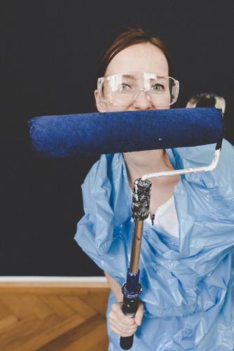 Woman in protective clothes showing a blue paint roller Freizeit & Hobby feminin Frau Erwachsene 1 Mensch 18-30 Jahre Jugendliche 30-45 Jahre Kreativität