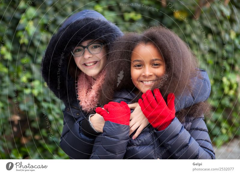 Zwei glückliche Mädchen im Park mit Mänteln. Freude Glück schön Gesicht Winter Kind Mensch Familie & Verwandtschaft Freundschaft Kindheit Mantel Schal