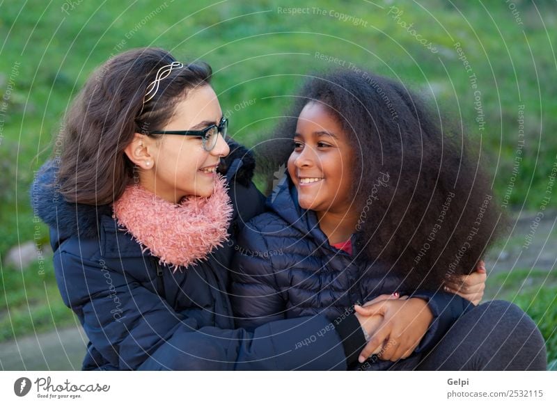 Zwei glückliche Mädchen im Park mit Mänteln. Freude Glück schön Gesicht Winter Kind Mensch Familie & Verwandtschaft Freundschaft Kindheit Gras Mantel Schal