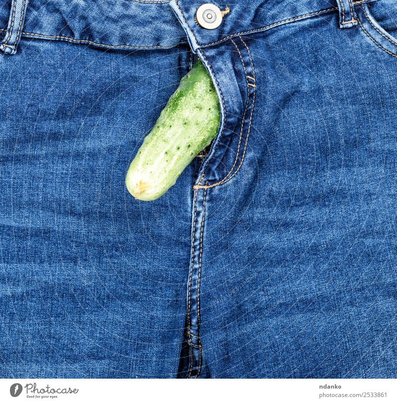 Gurke ragt aus der Blue Jeans heraus. Gemüse Freude Hose Jeanshose Stoff blau grün Sex Idee Mode Sexualität Salatgurke Hintergrund Beautyfotografie