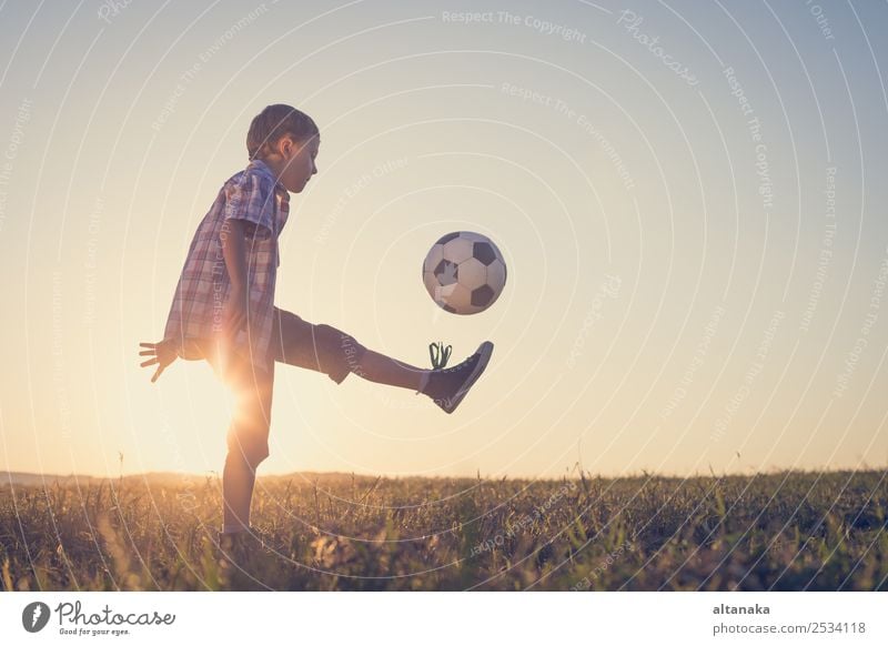 Kleiner Junge spielt auf dem Feld mit einem Fussball. Begriff des Sports. Lifestyle Freude Glück Erholung Freizeit & Hobby Spielen Sommer Fußball Kind Mensch