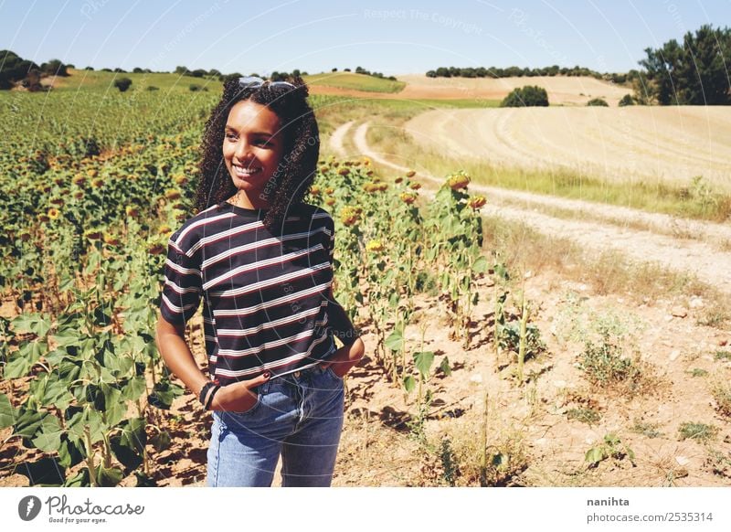 Junge Frau genießt den Tag in einem Feld mit Sonnenblumen. Lifestyle Stil Wellness Ferien & Urlaub & Reisen Freiheit Sommer Sommerurlaub Mensch feminin