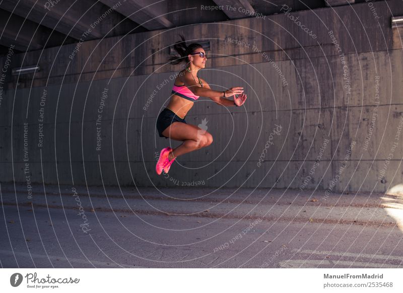 athletische Frau beim Springen Lifestyle schön Körper Sommer Sport Joggen Erwachsene Fitness Läufer Dehnübung Großstadt üben Training Athlet Aufwärmen jung