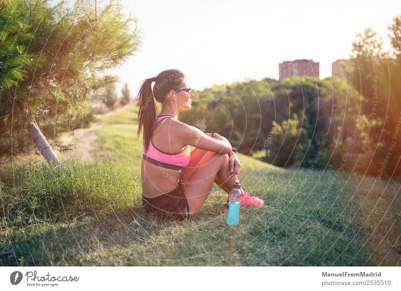 athletische Frau, die sich ausruht Flasche Lifestyle schön Sommer Sport Erwachsene Natur Park Fitness sitzen Energie Training Läufer aussruhen