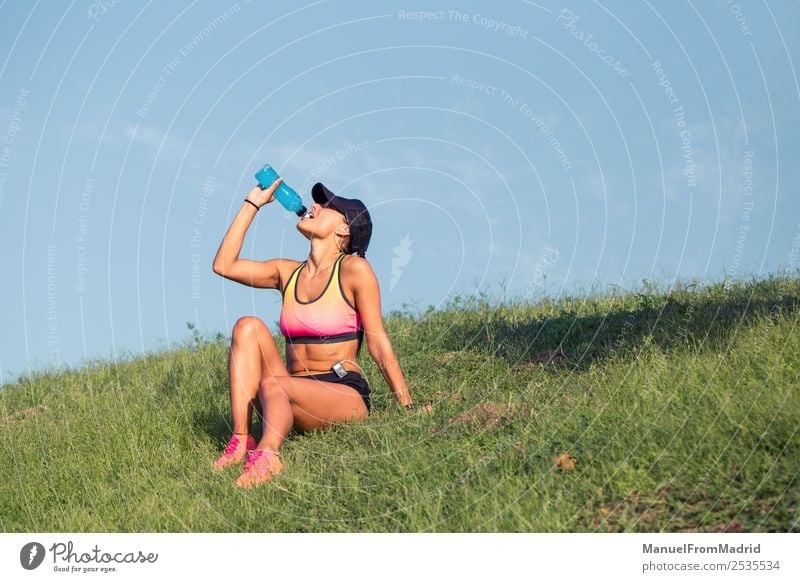 sportliche Frau, die sich ausruht und trinkt trinken Flasche Lifestyle schön Sommer Sport Erwachsene Natur Park Fitness sitzen Energie Training Läufer
