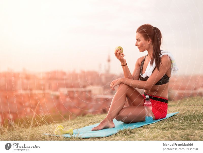 athletische Frau beim Essen eines Apfels Frucht Lifestyle schön Körper Wellness Sommer Sport Joggen Mensch Erwachsene Natur Park Fitness sitzen grün Athlet jung