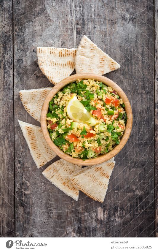 Tabbouleh-Salat auf Holztisch Tisch Salatbeilage Couscous Gemüse Tomate Gurke Salatgurke Petersilie Minze Vegane Ernährung Vegetarische Ernährung