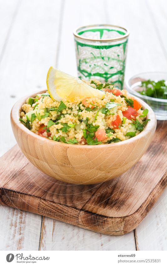 Tabbouleh-Salat in Schüssel auf weißem Holz Tisch Salatbeilage Couscous Gemüse Tomate Gurke Salatgurke Petersilie Minze Vegane Ernährung Vegetarische Ernährung