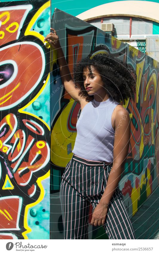 Urbane Frau mit Graffiti Lifestyle exotisch Freude Wellness Junge Frau Jugendliche Kunst Kultur Jugendkultur Stadt Mauer Wand Mode Afro-Look blau Lebensfreude