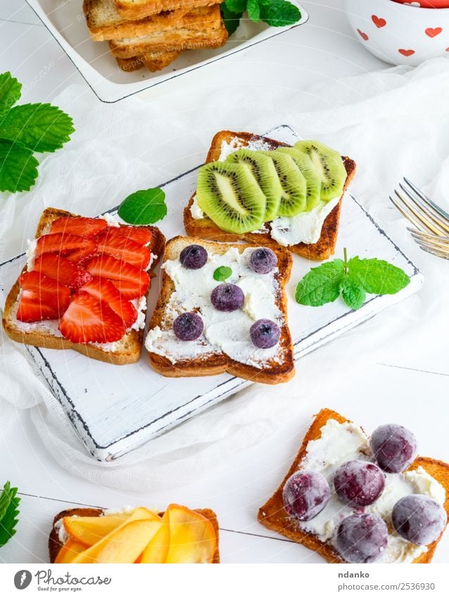 Französische Toasts mit Weichkäse Käse Frucht Brot Frühstück Mittagessen Holz oben weich grün weiß Erdbeeren Zuprosten Kiwi Blaubeeren Molkerei Persimone