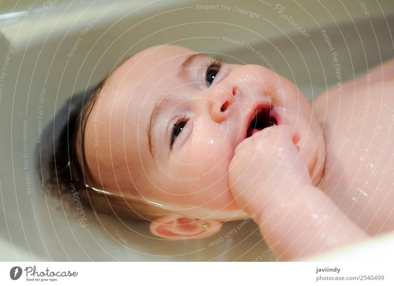 Kleines Mädchen vier Monate alt, das ihr Bad nimmt und lächelt. Glück schön Gesicht Leben Badewanne Kind Mensch feminin Baby Kindheit 1 0-12 Monate schlafen