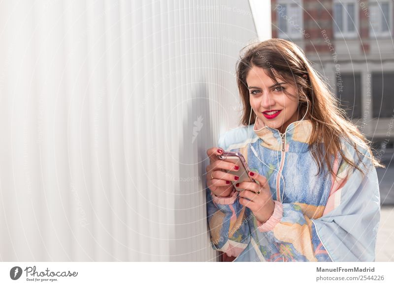 junge Frau mit Telefon mit Blick auf die Kamera Lifestyle Glück schön Musik PDA Fotokamera Technik & Technologie Mensch Erwachsene Lächeln niedlich klug