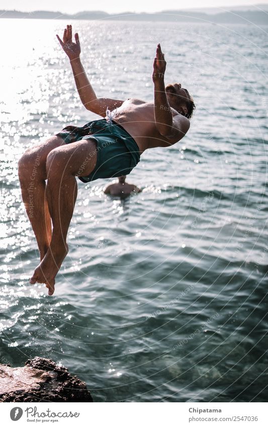 Mann, der an einem Strand zurückspringt. Wasser Freude MEER Sand Rückwärtssalto Sommer Erholung Freiheit Ferien & Urlaub & Reisen Aktion Artist Brandung Glück