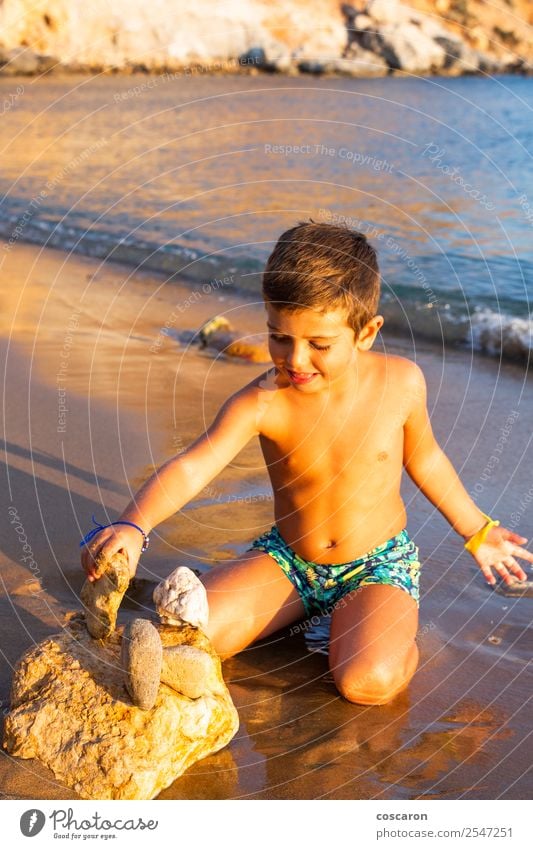 Kleines Kind, das am Strand mit Steinen baut. Lifestyle Freude Glück Spielen Ferien & Urlaub & Reisen Tourismus Sommer Sonne Meer Mensch maskulin Baby Kleinkind