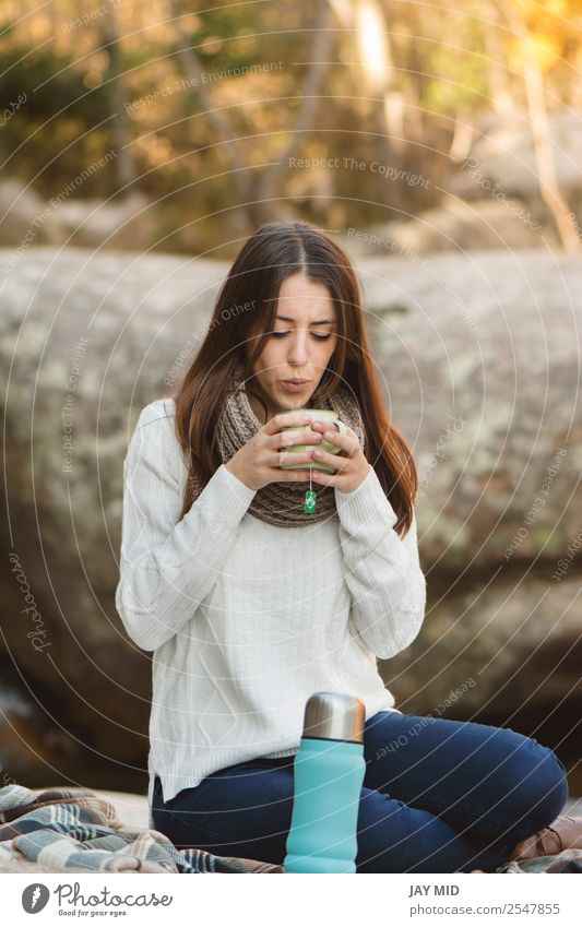 Junge Frau sitzt auf dem Felsen und trinkt Tee. Lebensmittel Milcherzeugnisse Kaffeetrinken Getränk Heißgetränk Tasse Lifestyle Erholung Freizeit & Hobby