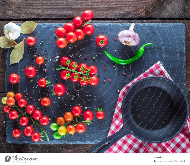 Pfanne und reife rote Kirschtomaten Gemüse Kräuter & Gewürze Vegetarische Ernährung Sommer Küche Holz Essen frisch klein natürlich oben grün schwarz Kirsche