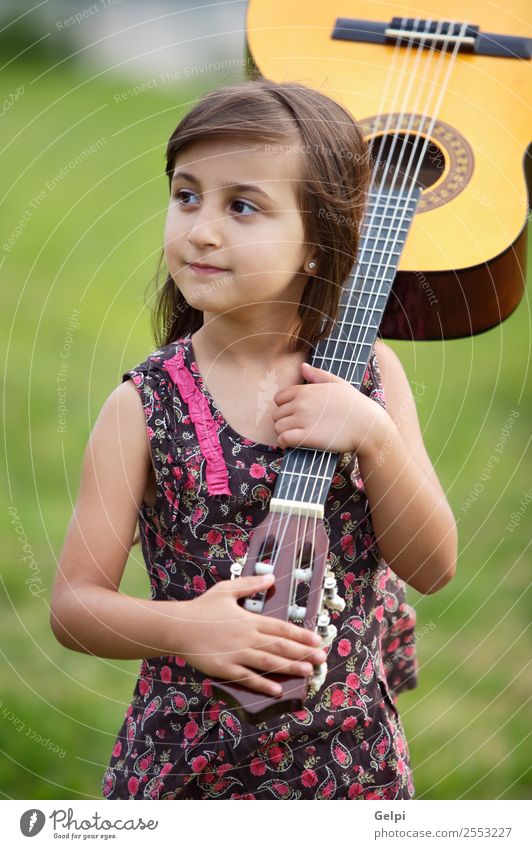 Mädchen mit einer Gitarre auf dem grünen Gras Musik Kind Schule Mensch Junge Musiknoten Blume rosa Schüler Spanisch gutaussehend Menschen Instrument