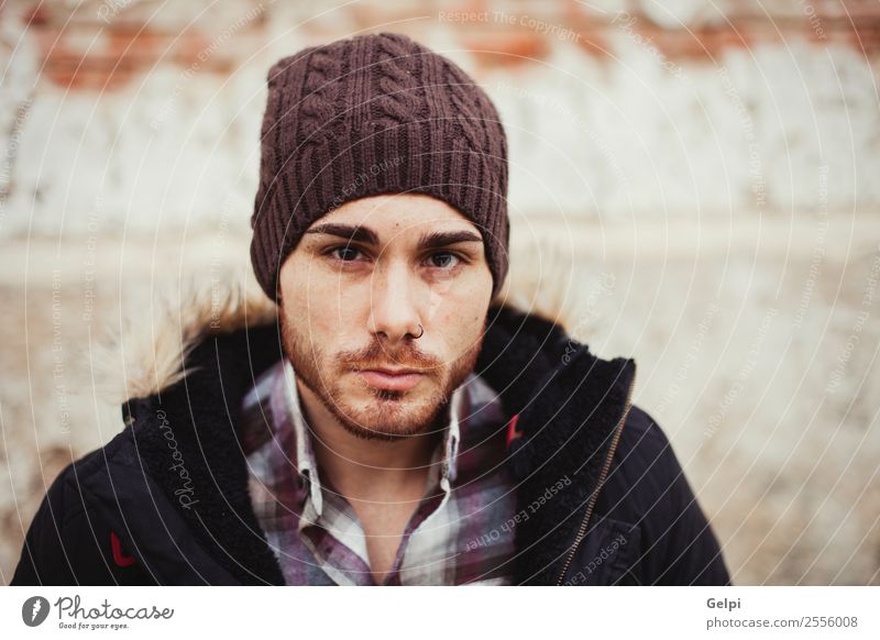 Porträt eines attraktiven Mannes mit Wollmütze in einem alten Haus Lifestyle Stil Mensch Junge Erwachsene Wärme Mode Piercing Hut Vollbart Coolness Erotik