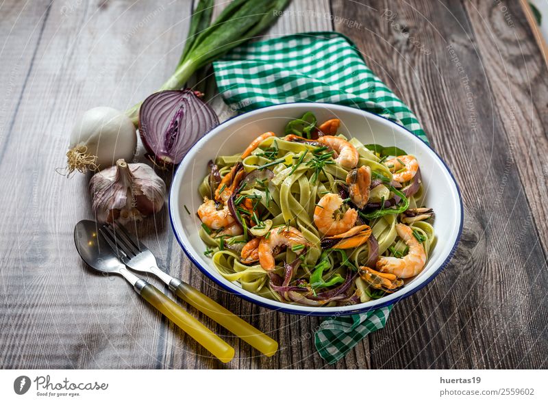 Grüne Tagliatelle mit Meeresfrüchten. Lebensmittel Gemüse Brot Italienische Küche Teller Gabel Tisch Gastronomie Muschel lecker oben sauer Spätzle Garnelen