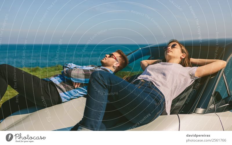 Junges Paar auf der Windschutzscheibe liegend Lifestyle Stil Erholung ruhig Ferien & Urlaub & Reisen Freiheit Sonnenbad Meer Mensch Frau Erwachsene Mann Natur