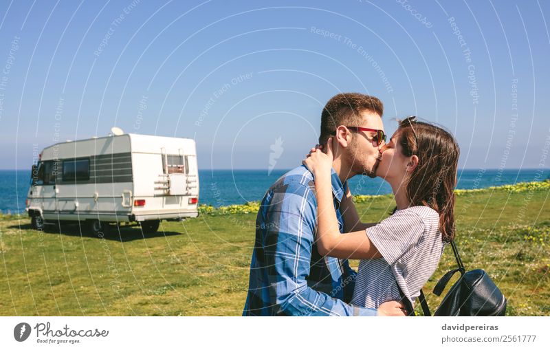 Ein Paar, das sich in Küstennähe mit einem Camper küsst. Lifestyle Glück Ferien & Urlaub & Reisen Abenteuer Freiheit Meer Mensch Frau Erwachsene Mann Gras Wiese