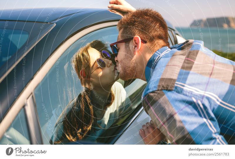 Junges Paar küssen durch von Glas Auto Lifestyle Ferien & Urlaub & Reisen Abenteuer Ferne Meer Mensch Frau Erwachsene Mann Gras Wiese Küste Fahrzeug PKW
