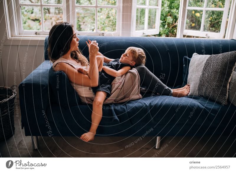 kaukasische Mutter und Sohn entspannen sich gemeinsam auf der Couch zu Hause. Lifestyle Stil Glück schön Erholung Spielen Sofa Kindererziehung Junge Frau