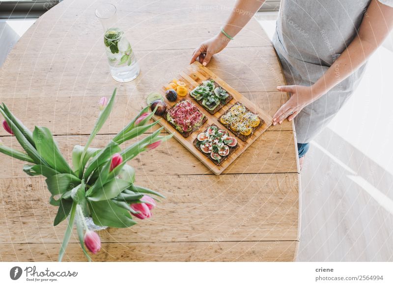 junge Frau serviert leckeres Brot mit Gemüse auf dem Tisch Essen Frühstück Mittagessen Diät Flasche Lifestyle Stil Dekoration & Verzierung Küche Hand Blume Holz