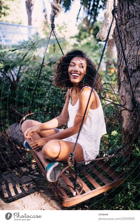 afrikanische junge Frau auf der Schaukel im Garten sitzend Lifestyle Glück schön Erholung Sommer Mensch Erwachsene Natur Pflanze Baum genießen Lächeln schaukeln