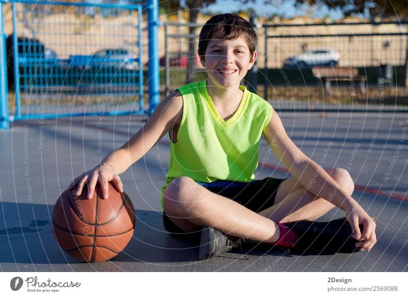 Junger Basketballspieler auf dem Platz sitzend Lifestyle Freude Erholung Freizeit & Hobby Spielen Sport Mann Erwachsene Jugendliche Straße authentisch Coolness