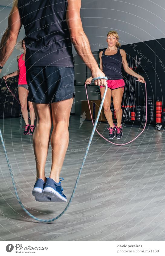Unbekannter Trainer unterrichtet Übungen mit Springseilen in einem Fitnesskurs Glück Körper Sport Schule Seil Frau Erwachsene Mann Arme Menschengruppe
