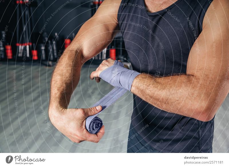 Mann wickelt die Hände mit Verbänden ein, bevor er das Boxtraining beginnt. Körper Sport Mensch Erwachsene Hand Handschuhe Fitness authentisch muskulös stark