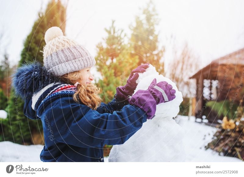 glückliches Kind Mädchen macht Schneemann in den Weihnachtsferien Freude Freizeit & Hobby Spielen Ferien & Urlaub & Reisen Winter Garten Natur Wetter Park