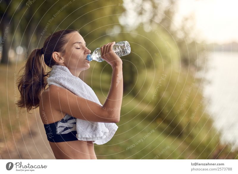 Passgenaue, sportliche Frau, die Wasser aus der Flasche trinkt. Sport Erwachsene 1 Mensch 18-30 Jahre Jugendliche Park Fitness Training jung üben Gesundheit