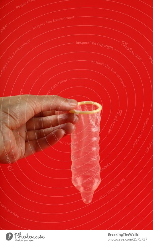 Nahaufnahme Frau Hand hält Kondom über Rot Gesundheit Gesundheitswesen Medikament Mensch Erwachsene Mann rot Sicherheit Schutz Verantwortung Vorsicht Farbe